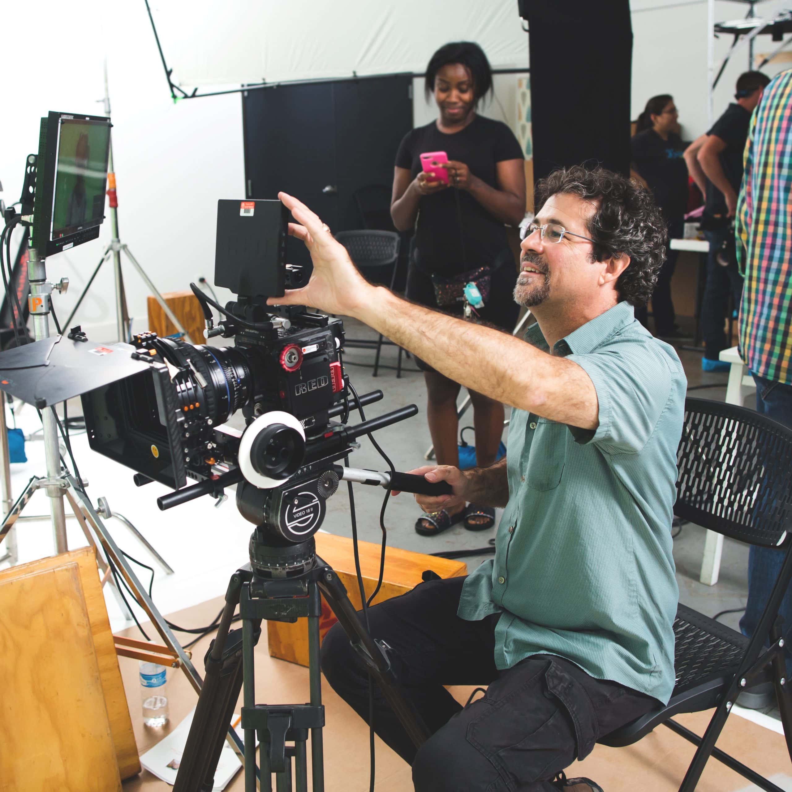 A camera operator adjusts his monitor